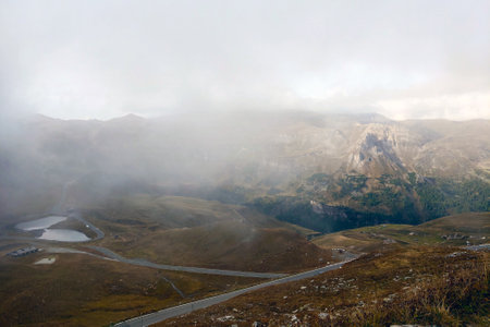 Beautiful view of the Alps mountains in a foggy autumn morning high in the mountainsの写真素材