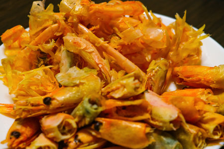 Leftovers from boiled shrimp on a white plateの写真素材