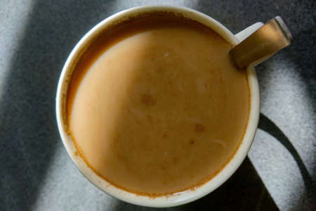The light falls beautifully on a mug of freshly brewed coffeeの写真素材