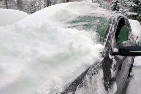 Cleaning a car from a large amount of snowの写真素材