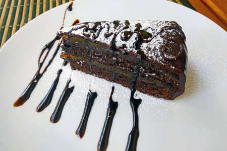 Delicious dark chocolate piece of cake on a white plateの写真素材