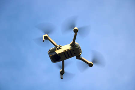 A drone flies in the air against the background of the blue skyの写真素材