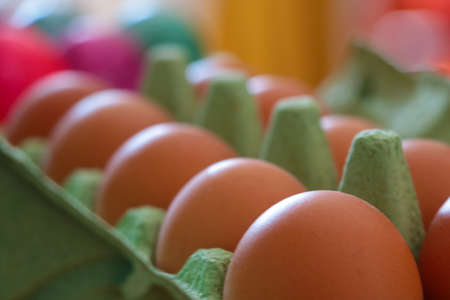 Beautiful yellow homemade eggs in cardboard packaging on the tableの写真素材