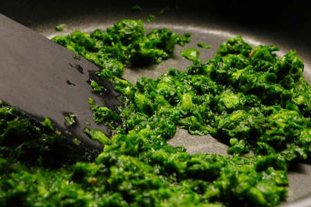 Cook green spinach in a frying panの写真素材