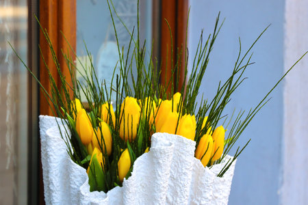 Bouquet of yellow fresh tulips on the window in a vaseの写真素材