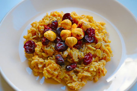 A plate of healthy light porridge, nuts and dried cranberries. Healthy food, dietの写真素材