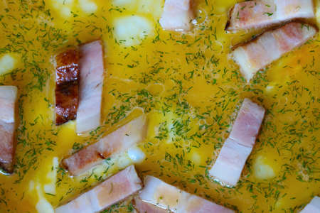 A close-up view of the egg and pieces of meat. Light breakfastの写真素材