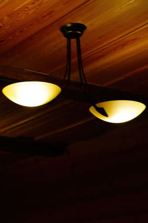 Blurry background, out of focus. Wooden ceiling with lamp