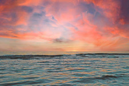 A picturesque sunset by the sea or ocean on a summer dayの写真素材