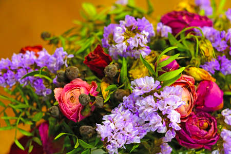 View of a bouquet of different flowers in a vase on the tableの写真素材