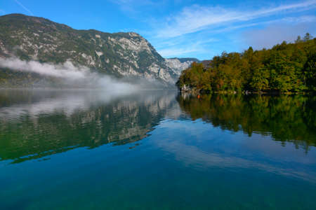A little fog on the shore of a mountain lake in the morningの写真素材