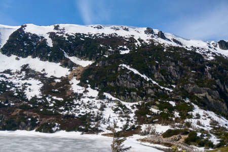 The tops of the mountain are in the snow on a sunny dayの写真素材