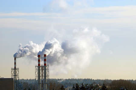From the chimney there is smoke in winter against the skyの写真素材