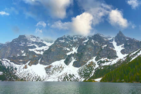 Lake against the backdrop of mountains and blue skyの写真素材