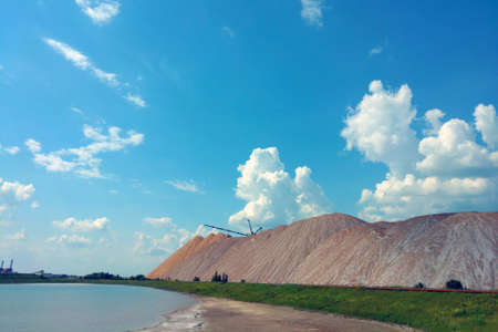 A large mountain of spent ore against the background of a blue skyの写真素材
