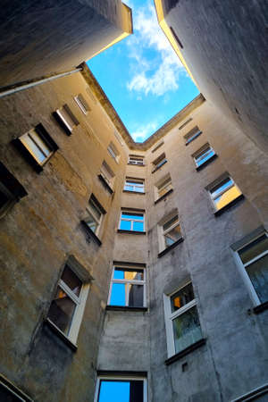 Beautiful narrow courtyard of an old house. Looking up from the bottom upの写真素材