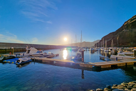Madeira, Portugal, 27 November 2022: Pier with modern boats during sunset or sunrise. Luxury yachts and boats. Rest on the sea or ocean. Walking cloudy sport, cruise, vacation.のeditorial素材