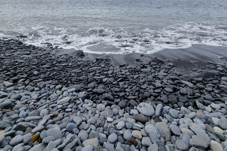 The waves wash the rocks. Volcanic coast. The background of the coastの写真素材