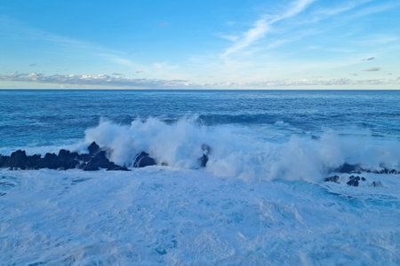 The waves of the sea or ocean crash against the rocks of the islandの写真素材
