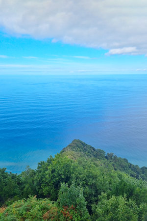 View from above the green slope of the island and the Atlantic Oceanの写真素材