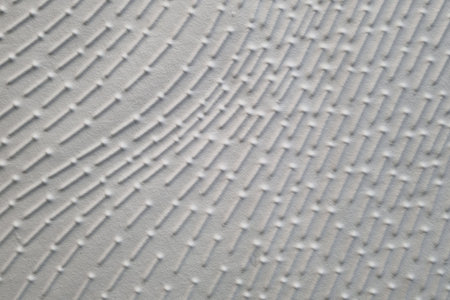Close-up of a textured white surface featuring a geometric pattern with raised dots and lines creating a sense of depth and dimension. ideal for backgrounds or design elements in creative projects.の写真素材