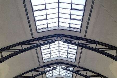 Skylight ceiling featuring large glass panels framed by sleek steel beams. the geometric design allows natural light to illuminate the interior, creating a contemporary and airy atmosphere within the space.の写真素材