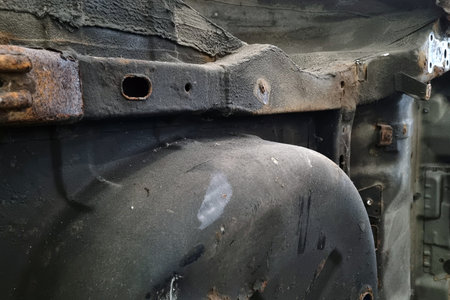 Close-up view of a rusty vehicle undercarriage showcasing aged metal and corrosion. the texture and colors emphasize the impact of time and elements on automotive components, ideal for restoration and repair concepts.の写真素材
