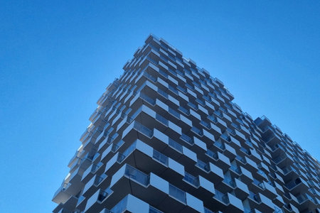 Abstract facade of a modern high-rise building showcasing geometric patterns against a cloudless...