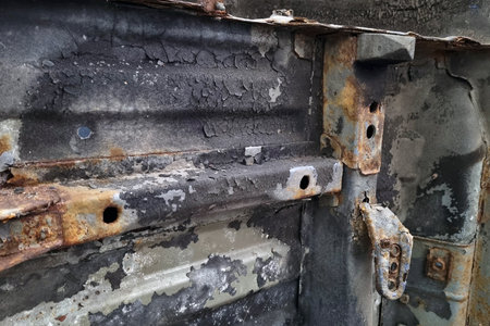 Close-up of a weathered industrial metal surface showcasing rust, peeling paint, and corrosion....