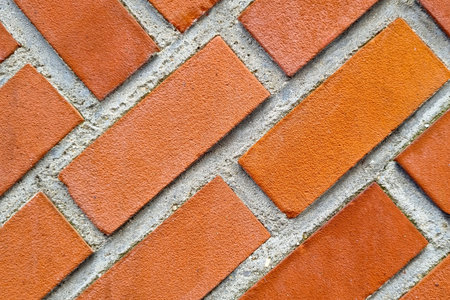 Close-up view of a red brick wall showcasing a classic diagonal pattern. the textured surface...