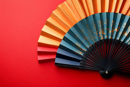 A stunning decorative fan with a gradient of orange, gold, and blue hues against a vibrant red background. ideal for asian-inspired designs, cultural themes, and artistic projects. Generative AIの素材