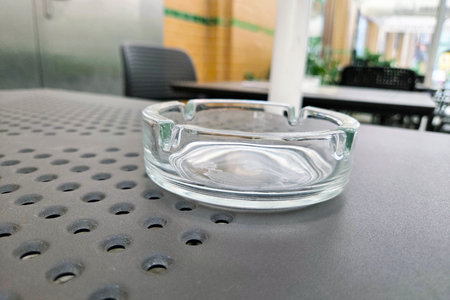 Outdoor Cafe Scene with Glass Ashtray on Metal Table in Urban Settingの写真素材