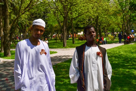 PYATIGORSK, RUSSIA - MAY 09, 2011: African men are dressed in national costumes and in solidarity pinned St. George Ribbon.のeditorial素材