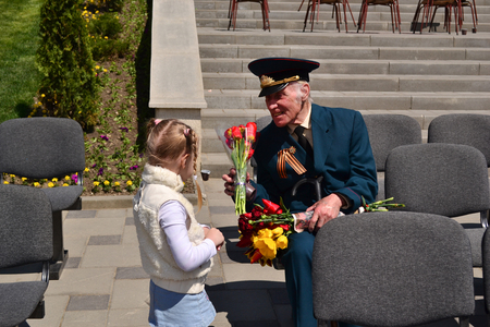 PYATIGORSK, RUSSIA - MAY 09, 2011: Girl gives flowers to veteran on Victory Day. 9 mayのeditorial素材
