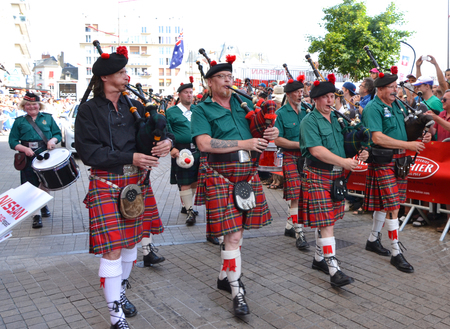 LE MANS, FRANCE - JUNE 13, 2014: Scottish bagpipe band is marching down the street during parade of...