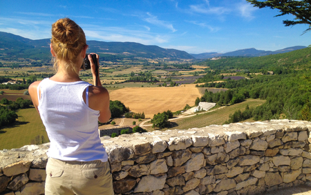 Girl takes pictures of the landscape of Provence, Franceの写真素材