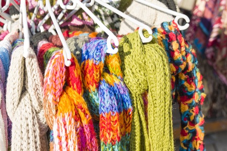 Many knitted scarves hang on the hanger in the marketの写真素材
