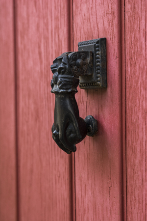 Red old door with doorknocker Metal arm of woman or manの写真素材