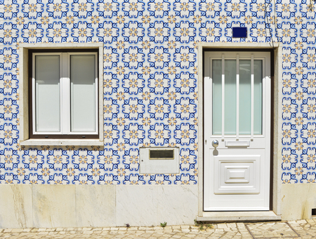 Facade of the house with ancient tiles in Portugalの写真素材