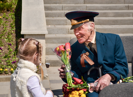 PYATIGORSK, RUSSIA - MAY 09, 2011: Girl gives flowers to veteran on Victory Day.のeditorial素材