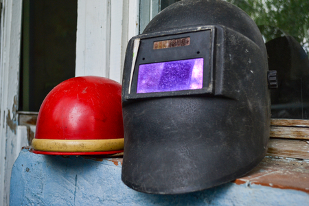 Two dirty old welding helmets after workの写真素材