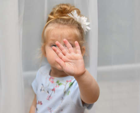 The little girl covers her face with her hand. Please, no picture.