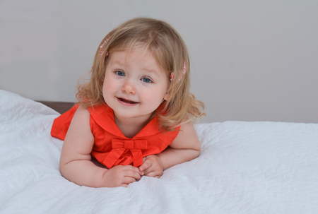 Portrait of a girl with blue eyes in a red dressの写真素材