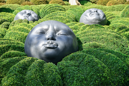 ETRETAT, FRANCE - SEPTEMBER 02, 2018: Giant rubber heads sleeping on green pillows. Boxwood garden in the famous garden of Etretat, Normandy, Franceのeditorial素材