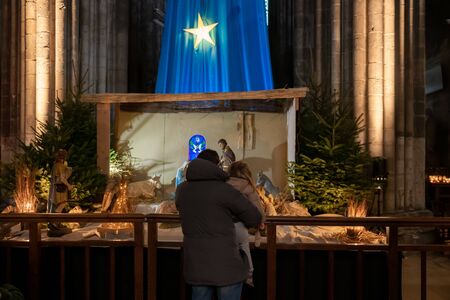Father and daughter look at the Christmas nativity sceneの写真素材