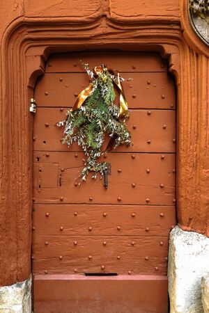 Old metal door with studs in the shape of a pyramid with a christmas decorationの写真素材