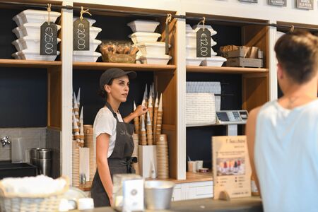 VERONA, ITALY - AUGUST 16, 2019:A girl prepares ice cream in the famous cafeteria La Romana