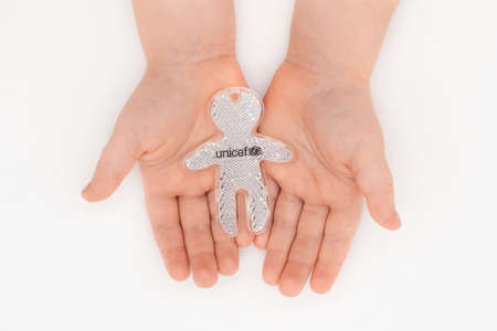PARIS, FRANCE - MAY 17, 2020Children's hands holding a small figure with the UNICEF symbol Isolated on white background.のeditorial素材