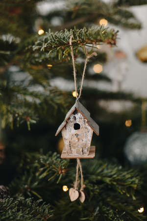 Wooden birdhouse hanging on the Christmas treeの写真素材
