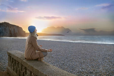 A woman doing yoga at the beachの写真素材